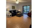 Inviting living room featuring neutral walls, tile floors, comfortable seating, and sliding glass doors to a private outdoor patio at 1515 Forrest Nelson Blvd # A208, Port Charlotte, FL 33952