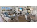 Bright living room features wicker furniture, a large TV, and stylish coastal decor at 5850 Gasparilla Rd # M1&3, Boca Grande, FL 33921