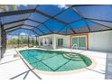 Inviting kidney-shaped pool with a screened enclosure in a sunny backyard at 9660 Miami Cir, Port Charlotte, FL 33981