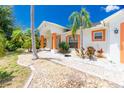 Front exterior of charming single story home with orange accents and landscaping at 9660 Miami Cir, Port Charlotte, FL 33981