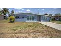 Ranch-style home with light blue exterior and a paved driveway at 22216 Midway Blvd, Port Charlotte, FL 33952