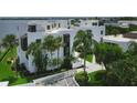 Aerial view of condo building with lush landscaping and palm trees at 2955 N Beach Rd # A-415, Englewood, FL 34223