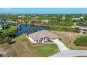 Aerial view of waterfront property with canal access and lush landscaping at 14091 Peekskill Ave, Port Charlotte, FL 33981