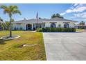 Exterior view of a single-Gathering home with a well-maintained lawn and a flag at 254 Orlando Blvd, Port Charlotte, FL 33954