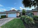 Two-car garage with landscaping and paver driveway at 2095 Lynx Run, North Port, FL 34288