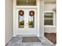 White double front doors with glass panels and fall wreaths at 9317 Panama Cir, Port Charlotte, FL 33981