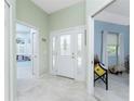 Bright foyer with decorative glass front door and tiled floors at 13074 Via Flavia, Placida, FL 33946
