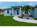 Front view of a teal house with a landscaped walkway at 12112 Helios Ave, Port Charlotte, FL 33981