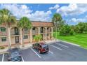 Two-story condo building with balconies and palm trees at 235 Rotonda Blvd W # C203, Rotonda West, FL 33947
