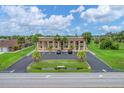 Aerial view of condo building with ample parking and lush landscaping at 235 Rotonda Blvd W # C203, Rotonda West, FL 33947