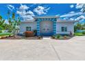 Single story home with teal accents and landscaping at 6551 Hamlet Dr # 22A, Englewood, FL 34224