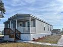 Beautiful single story home featuring gray siding, a covered porch and meticulous landscaping at 1377 Ibis Dr, Englewood, FL 34224