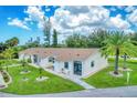 Exterior view of a light-colored building with a brown roof and lush lawn at 6796 Gasparilla Pines Blvd # 48, Englewood, FL 34224