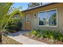 Inviting front entrance with stylish door, green shutters, and manicured plants at 6517 Kenwood Dr, North Port, FL 34287