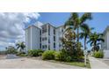 Exterior view of a condo building with palm trees and walkway at 7070 Placida Rd # 1221, Placida, FL 33946