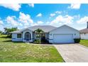 Single-story home with a two-car garage and landscaped yard at 189 Bunker Rd, Rotonda West, FL 33947
