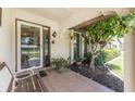Inviting front porch with tiled flooring, wooden bench, and lush landscaping at 1867 Neptune Dr, Englewood, FL 34223