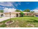 Single-story house with a two-car garage and landscaped yard at 1867 Neptune Dr, Englewood, FL 34223