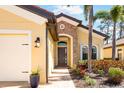 Close up view of a home's front entrance featuring a stone archway, beautiful landscaping, and a front-facing two car garage at 1012 Bradberry Dr, Nokomis, FL 34275