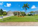 House exterior view, showcasing a two-car garage and manicured lawn at 14089 Newson Ln, Port Charlotte, FL 33981