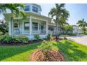 Stunning two-story home with a covered porch, manicured landscaping, and a circular driveway at 200 Capstan Dr, Placida, FL 33946