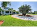 Beautiful home with a circular driveway, lush lawn, and well-maintained landscaping at 200 Capstan Dr, Placida, FL 33946