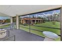 Screened porch with patio furniture and view of the community at 6 Quails Run Blvd # 7, Englewood, FL 34223