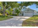Two-story home with a large driveway and mature landscaping at 1730 Padre Ln, Englewood, FL 34223