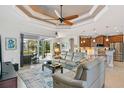Spacious living room with light leather sofas, a large TV, and access to a pool and patio at 15964 Viscount Cir, Port Charlotte, FL 33981