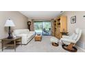 Living room features white leather seating, wood cabinet, and pool view at 7293 Spinnaker Blvd, Englewood, FL 34224