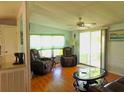 Comfortable living room with hardwood floors, recliners and large windows at 6246 Parakeet Rd, Englewood, FL 34224