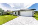 New construction home with a white garage door and paver driveway at 213 Antis Dr, Rotonda West, FL 33947