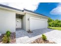 Modern house exterior with white garage door and gray stone walkway at 213 Antis Dr, Rotonda West, FL 33947