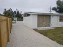 Backyard view with a detached structure and gravel driveway at 1157 South Ln, Englewood, FL 34224