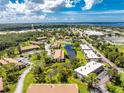 Aerial view of condo community featuring serene pond, lush landscaping, and convenient parking at 3 Quails Run Blvd # 8, Englewood, FL 34223