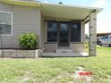 The home features a cozy, screened front entrance with beautiful brick accents and lovely shrubbery at 6186 Redwing Ave, Englewood, FL 34224