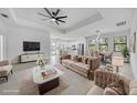 Staged living room with plush furniture, adjacent dining area, and open to modern kitchen at 9262 Genesee St, Port Charlotte, FL 33981