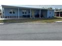 Front view of a light blue single wide manufactured home with covered carport at 6432 Keena Ct, North Port, FL 34287