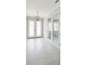 Bright foyer with white tile floors and french doors at 5240 Willow Lake Ct, Sarasota, FL 34233