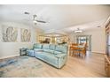 Open living space with light floors and blue couch, view of kitchen and dining area at 9273 Carnation Ave, Englewood, FL 34224