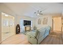 Living room with light flooring, blue couch, and large TV at 9273 Carnation Ave, Englewood, FL 34224