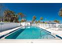 Sparkling community pool surrounded by a white fence and lounge chairs, perfect for relaxation at 470 S Mccall Rd # 10, Englewood, FL 34223