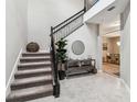 Elegant staircase featuring a wrought iron banister, plush carpet, and stylish decor at 7537 Pool Compass Loop, Wesley Chapel, FL 33545