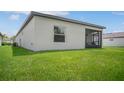 Back of house showing screened patio and grassy backyard at 1352 Sunset Preserve Way, Port Charlotte, FL 33953