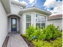 Inviting home exterior with a gray front door and lush landscaping at 9982 Beachwalk Dr, Englewood, FL 34223