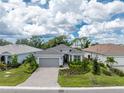 Single-Gathering home with gray roof and paver driveway at 9982 Beachwalk Dr, Englewood, FL 34223