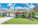 Single story home with a two-car garage and manicured lawn at 15584 Lakeland Cir, Port Charlotte, FL 33981