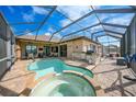 Inviting pool and spa with a covered patio and outdoor kitchen at 15584 Lakeland Cir, Port Charlotte, FL 33981