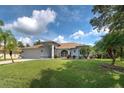 Single-story home with gray exterior, brown roof, and nicely landscaped lawn at 1502 Hazelton Ave, North Port, FL 34286