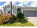 New home with gray siding, tile roof, and two-car garage, located in a residential community at 14589 Ponce De Leon Trl, Port Charlotte, FL 33981